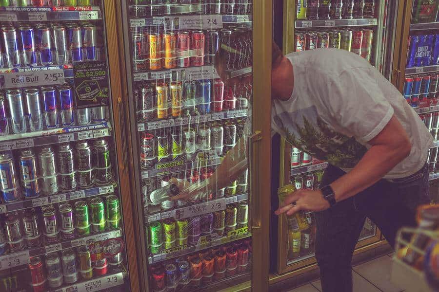 man getting energy drinks from store